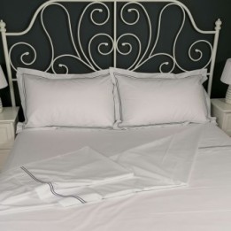 Flat sheet blue trim Egyptian Cotton 200 Thread Count Percale Porto laid out on bed